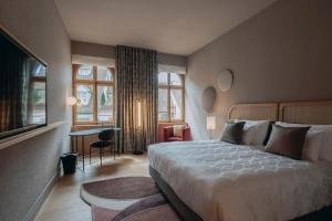 een hotelkamer met een groot bed en een bureau bij Hotel Märthof Basel in Bazel