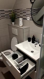 a white bathroom with a sink and a toilet at COSY CHAMBRE CHEZ HABITANT 5mn Aéroport Roissy CDG in Le Mesnil-Amelot