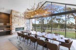 una grande sala da pranzo con un lungo tavolo e sedie di Spicers Guesthouse a Pokolbin