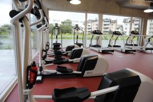 un gimnasio con filas de cintas de correr y elípticas en HOTEL APART - Welcoming l Urban Feel l Design, en Risch-Rotkreuz