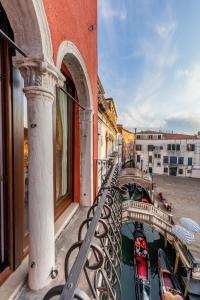 uma vista para um canal a partir de uma varanda com uma ponte em La Veneziana Boutique Rooms em Veneza