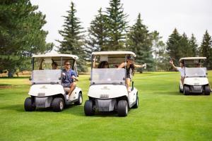 - un groupe de personnes à bord de voiturettes de golf sur un champ dans l'établissement Little America Hotel & Resort Cheyenne, à Cheyenne