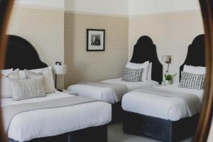 Tempat tidur dalam kamar di The Queens Hotel