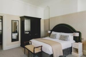 Tempat tidur dalam kamar di The Queens Hotel