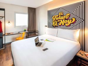 リマにあるibis styles Lima San Isidroのホテルルーム ノートパソコン付きのベッド付