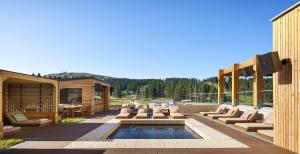 eine Terrasse mit einem Pool und Stühlen sowie ein Haus in der Unterkunft Viceroy Kopaonik Serbia in Kopaonik