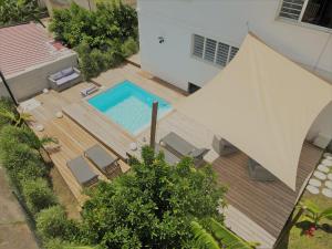 una terrazza in legno con vista sulla piscina. di Kozycoco - Suite Kozy - séjour tropical au calme a Schœlcher