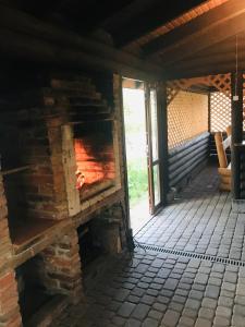 Una chimenea de ladrillo en una habitación con patio en Артемів двір, en Slavske