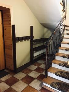 una escalera con barandillas de madera y suelo de baldosa en Артемів двір, en Slavske