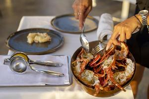 uma pessoa a comer uma tigela de comida numa mesa em Hôtel Capo Rosso em Piana