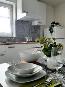 una cocina con 2 tazones blancos y platos en una encimera en Ferienwohnung "Am Blauwasser" mit Infrarotkabine, en Vogtsburg