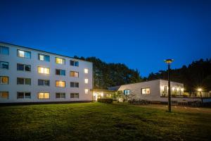 ein großes weißes Gebäude mit einem Rasenplatz in der Nacht in der Unterkunft Hotel Mukran in Sassnitz