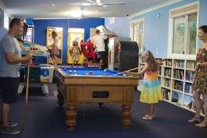 Eine Gruppe von Menschen, die in einer Bibliothek Billard spielen in der Unterkunft The Palms At Avoca in Avoca Beach