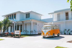 un furgone arancione parcheggiato di fronte a una casa. di Bounce Noosa a Noosaville