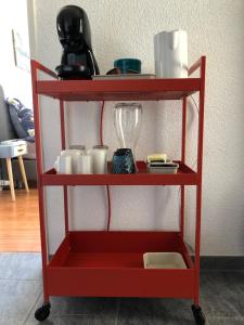 a red shelf with cups and other items on it at Gästezimmer Erlinsbach bei Aarau, zwischen Aare und Jura in Niedererlinsbach