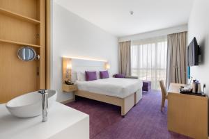 Habitación de hotel con cama y baño en Premier Inn Dubai Ibn Battuta Mall, en Dubái