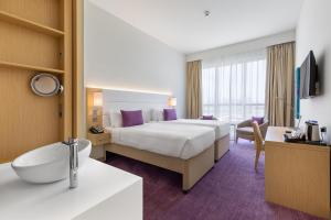 Habitación de hotel con cama y baño en Premier Inn Dubai Ibn Battuta Mall, en Dubái