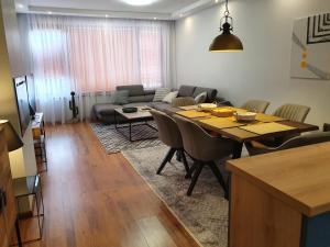 uma sala de estar com uma mesa e um sofá em Monteverde Ski Lift Apartment Bansko em Bansko