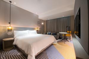 een hotelkamer met een groot bed en een tafel bij Holiday Inn Johor Bahru City Centre, an IHG Hotel in Johor Bahru