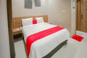 - une chambre avec un grand lit et des draps rouges dans l'établissement RedDoorz Premium @ Griya Inkoppabri Cisarua Puncak, à Bogor