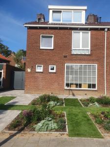 une maison en briques avec un jardin en face de celle-ci dans l'établissement Guesthouse de Hoogkamp, à Arnhem