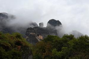 a mountain shrouded in fog with trees and rocks at Zosimas House in Kalabaka