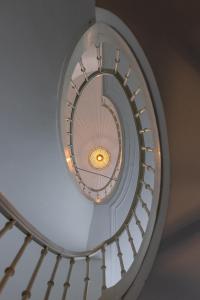 a spiral staircase with a light in the middle at Molenmeers Boutique Guesthouses in Bruges