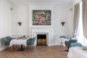 a dining room with two tables and a painting on the wall at Molenmeers Boutique Guesthouses in Bruges