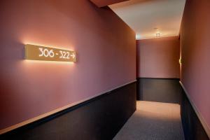 un couloir avec une horloge sur le mur dans l'établissement Boutique Hotel Seidenhof, à Zurich