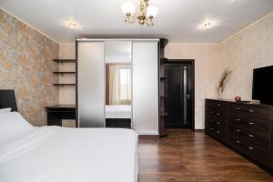 Lux Apartment Gorkiy Park في خاركوف: غرفة نوم بسرير وخزانة ومرآة