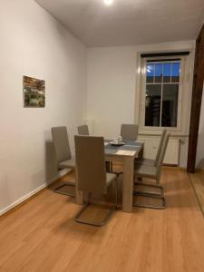 uma sala de jantar com uma mesa e cadeiras e uma janela em Ferienwohnung Eichhörnchen em Suhl