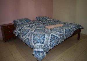 een bed in een slaapkamer met een blauwe en witte sprei bij Mamba Village Kisumu in Kisumu