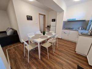 a kitchen and a table and chairs in a room at Holdudvar Apartman in Gyula