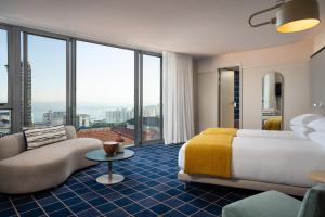 ein Hotelzimmer mit einem Bett und einem Sofa in der Unterkunft Home Suite Hotels Sea Point in Kapstadt