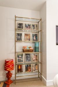 a shelf with pictures and a chair in a room at Molenmeers Boutique Guesthouses in Bruges