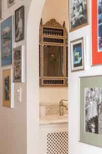 a bathroom with a mirror on a wall with pictures at Molenmeers Boutique Guesthouses in Bruges