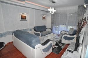 a waiting room with blue and white furniture in a room at Twins Apartments in Čačak