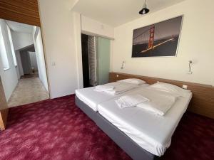 1 dormitorio con cama blanca y alfombra roja en Metro Apartments Vienna, en Viena