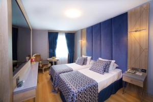 een hotelkamer met 2 bedden en een raam bij Aspen Hotel & SPA Istanbul Old City in Istanbul