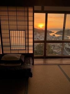 Cette chambre dispose d'une fenêtre offrant une vue sur la ville. dans l'établissement Onomichi Guest House Miharashi-tei, à Onomichi