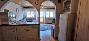 a kitchen with an archway and a kitchen with a refrigerator at Pokoje Centrum U Ani in Augustów