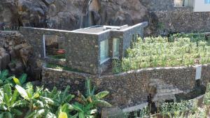 een huis gebouwd in een stenen muur bij Socalco Nature Calheta in Calheta