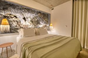 een slaapkamer met een groot bed en een schilderij aan de muur bij Socalco Nature Calheta in Calheta