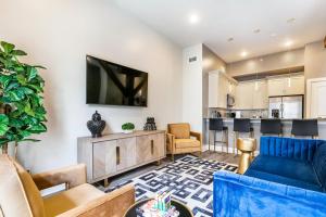 a living room with a blue couch and a kitchen at The Calliope in New Orleans