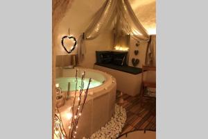 a bathroom with a tub and a heart shaped mirror at Les Secrets d'Alcôve, nuits Romantiques avec SPA in Aix-en-Provence