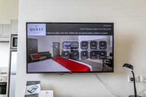 una TV a schermo piatto appesa a un muro di Quest New Plymouth Serviced Apartments a New Plymouth