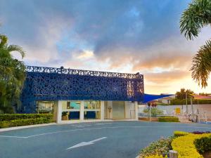 un edificio con struttura blu in un parcheggio di Alex Beach Cabins and Tourist Park ad Alexandra Headland