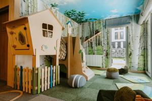 ein Kinderzimmer mit einem Spielbereich mit Spielhaus in der Unterkunft VISLOW Resort in Wisła