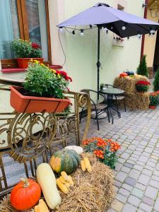 um pátio com uma mesa, um guarda-chuva e abóboras em Sunny Hotel em Lviv