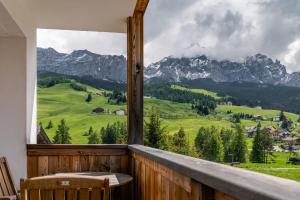 a room with a balcony with a view of mountains at Ciasa Agreiter in La Villa